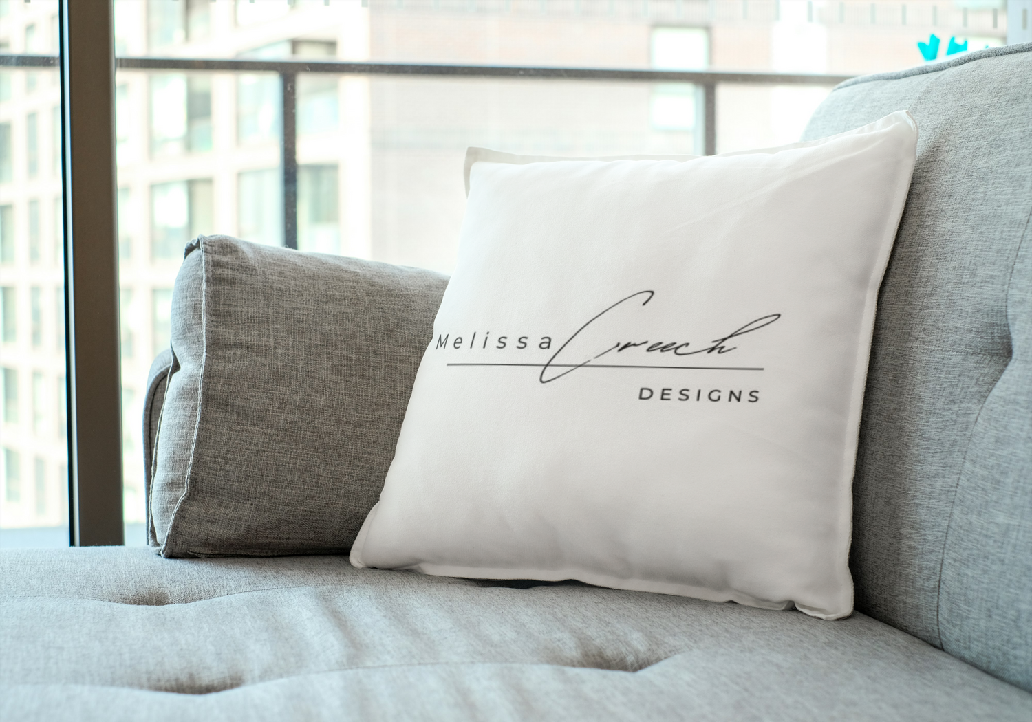 Melissa Creech Designs logo pillow on sofa